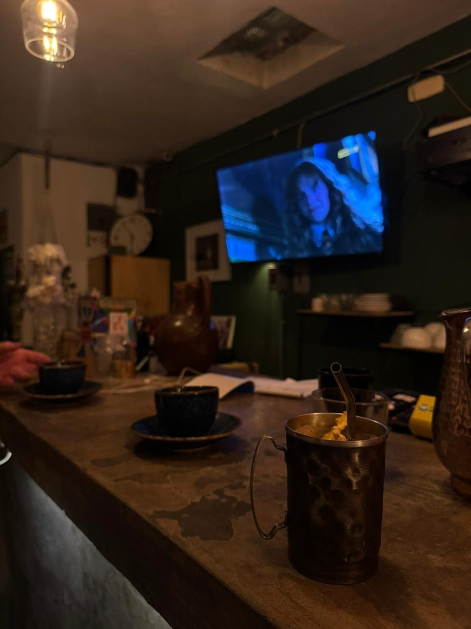 Diversión Interior de cafetería en Puebla con barra de madera, tazas de café y un ambiente cálido con iluminación tenue, transmitiendo la pelilcula de Harry Potter