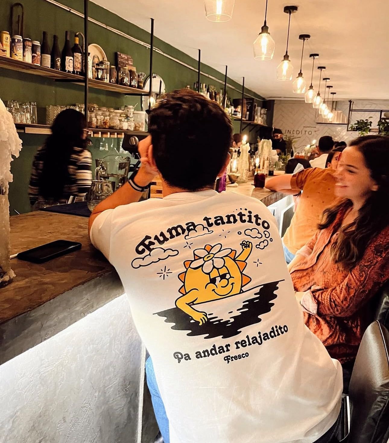 Diversión Un chavo en una barra de bar con playera de ilustración de sol en una experiencia con su novia